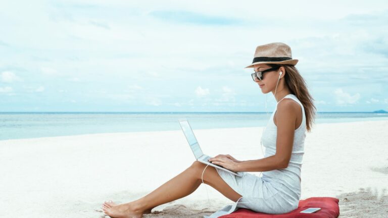 donna con pc in spiaggia